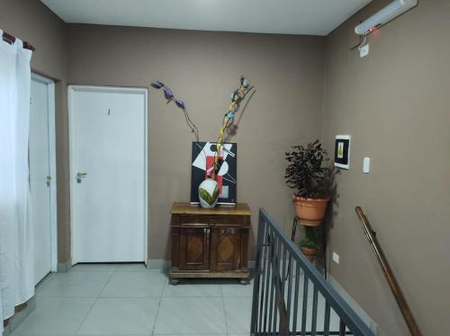 a hallway with a door and a vase on a table at Espacio Verde in Salta