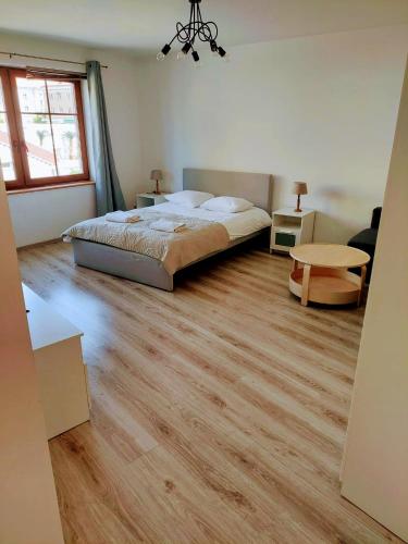 sypialnia z łóżkiem i drewnianą podłogą w obiekcie Drzewna Apartamenty-Kupiecka 66A w Zielonej Górze
