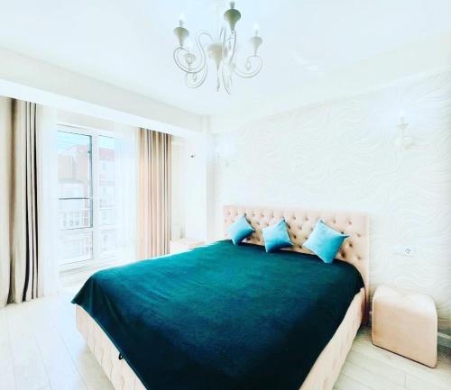 een slaapkamer met een groot bed met blauwe kussens bij Rent Apartament 2 camere Chirie in Chişinău