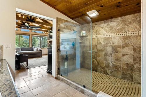 a glass shower in a room with a couch at Gorgeous North Fork Cabin Near Bass Lake! in North Fork