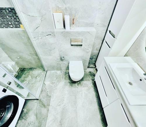 een badkamer met een wit toilet en een wastafel bij Rent Apartament 2 camere Chirie in Chişinău