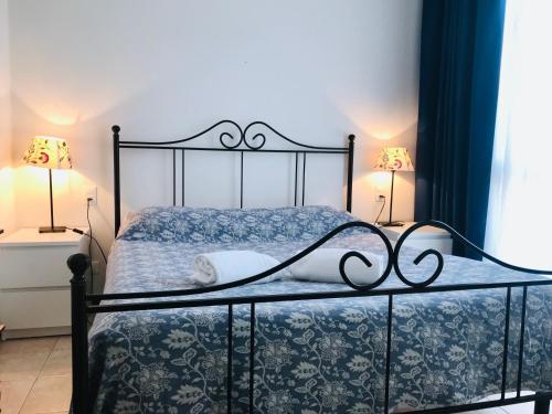 a bedroom with a bed with a black frame and two lamps at Appartamenti Leonardo in Brescia