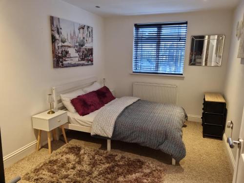 Apartment In Birmingham New Street في برمنغهام: غرفة نوم صغيرة بها سرير ونافذة