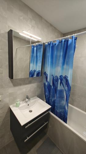 a bathroom with a sink and a shower curtain at Kavoliuko 14 in Vilnius