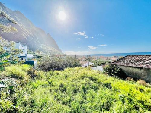a view of a hill with houses and a mountain at Haus am Meer by Your Madeira Rentals in Paul do Mar