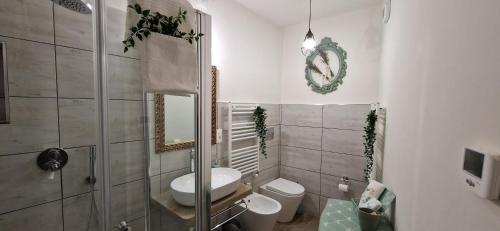 La salle de bains est pourvue de toilettes, d'un lavabo et d'un miroir. dans l'établissement Il Mulino B&B, à Rivara