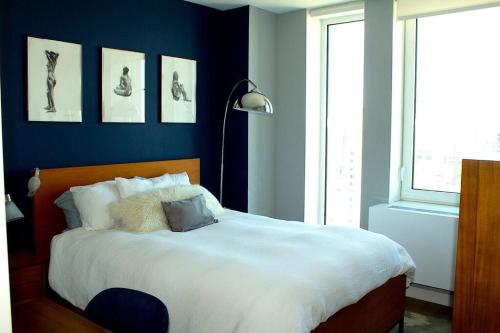 a bedroom with a large white bed and a window at LES is MORE stunning views! in New York