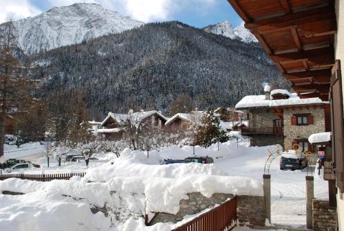 a village covered in snow with mountains in the background at Hotel Des Glaciers in Courmayeur