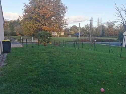 een park met een boom in het midden van een veld bij La maison de Marie 