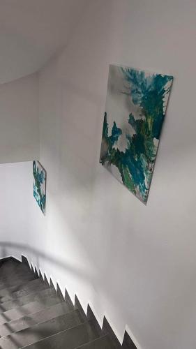 two paintings on the wall of a white wall at AXARA Holiday Home in Xagħra