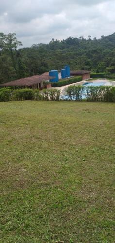 een grasveld met een gebouw en een zwembad bij Casa de campo in Pedro Vicente Maldonado