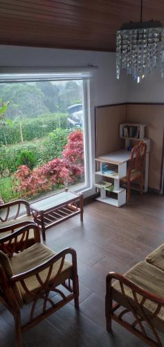 een kamer met een groot raam en een tafel en stoelen bij Casa de campo in Pedro Vicente Maldonado