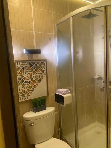 a bathroom with a toilet and a glass shower at Elegant 2BR, 2 BA Suite Beside Eastwood Mall in Manila