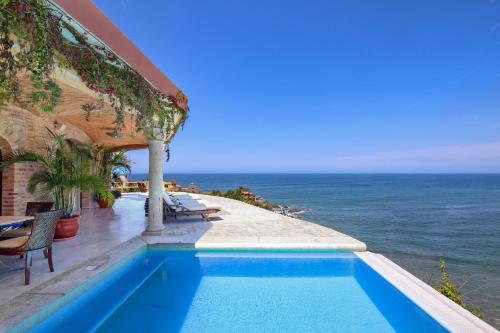 a swimming pool with the ocean in the background at Tia Adriana in Sayulita
