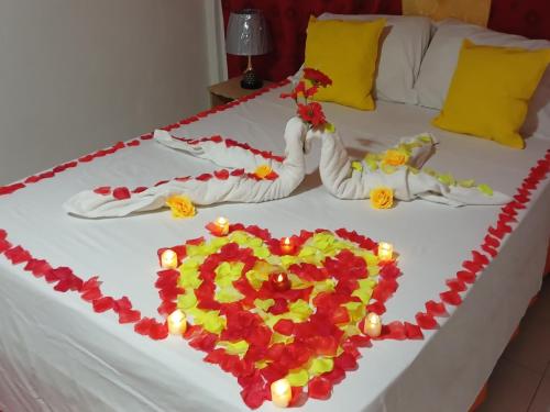 two beds with a heart made out of flowers at Cabañas Mister Mac in Providencia