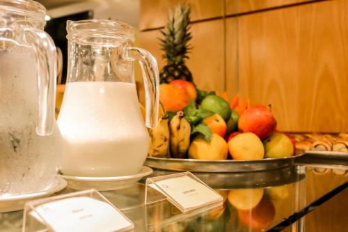 a jug of milk next to a bowl of fruit at Riale Vilamar Copacabana in Rio de Janeiro