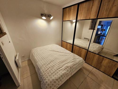 une chambre avec deux lits et un grand miroir dans l'établissement Appartement cosy centre ville proche chantiers navals, calanques, plages, à La Ciotat
