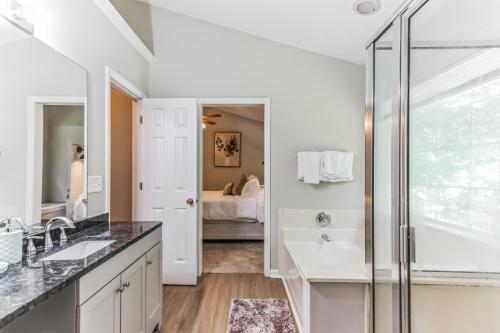 a white bathroom with a shower and a sink at Lowcountry haven - game rm + king bds, mins 2 dwtn in Charleston