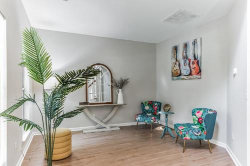 a living room with two chairs and a mirror at Lowcountry haven - game rm + king bds, mins 2 dwtn in Charleston