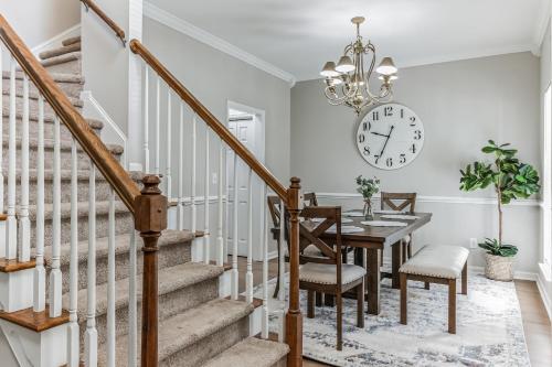 a dining room with a table and a clock on the wall at Lowcountry haven - game rm + king bds, mins 2 dwtn in Charleston