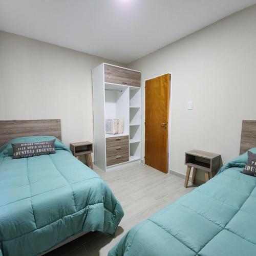 a bedroom with two beds and a closet at Estepa Sur Alojamiento Gaiman in Gaiman
