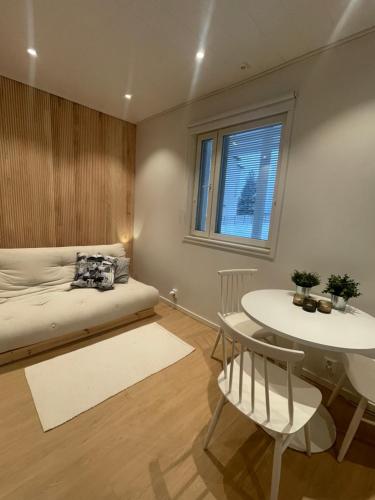 een slaapkamer met een bed en een tafel en stoelen bij Brand new 1 room cottage with sauna in Rovaniemi