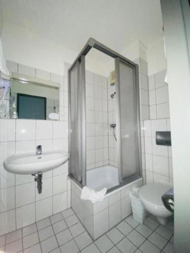 Un baño con lavabo, ducha e inodoro. en Hotel Christina, en Colonia