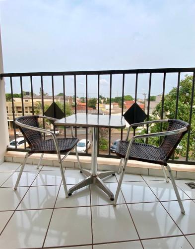 uma mesa e cadeiras numa varanda com vista em Apto charmoso na V Planalto perto Shopping com 2 Quartos ArCond Wifi Fibra Home Office e Garagem em Dourados em Dourados