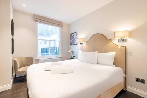 Un dormitorio con una gran cama blanca y una ventana en Luxury 2 bed in front of Museums, en Londres