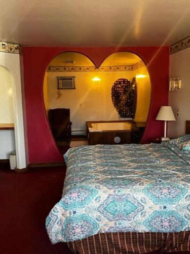 a bedroom with a bed with a heart shaped wall at Grand Howell Inn in Howell