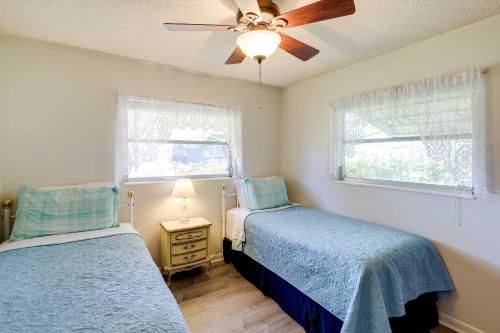 - une chambre avec 2 lits et un ventilateur de plafond dans l'établissement Merritt Island Home Less Than 10 Mi to Cocoa Beach!, à Merritt Island