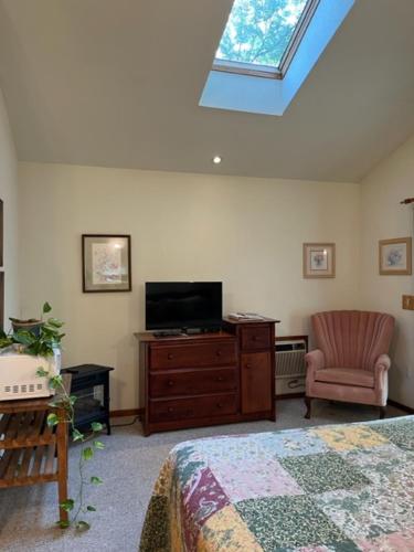 a bedroom with a bed and a tv and a chair at Backyard Garden Oasis in Middletown