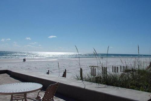 una mesa y sillas en una playa de arena en Hacienda del Sol II - 415, en New Smyrna Beach