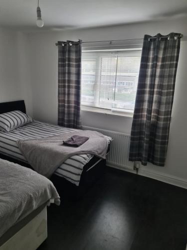 a bedroom with two beds and a window with curtains at Guest house room 1 in Haverfordwest