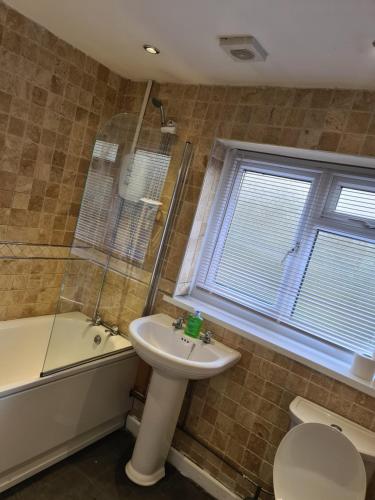 a bathroom with a sink and a toilet and a tub at Guest house room 1 in Haverfordwest