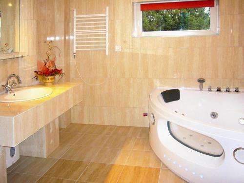 a bathroom with a tub and a sink and a window at Terraced house, Sieciemin in Sieciemin