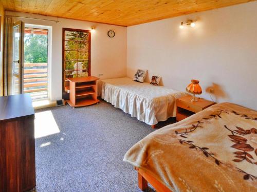 a bedroom with two beds and a window at Lakeside holiday home, private garden in Dąbrowica