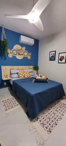 a bedroom with a large blue bed with a blue wall at Apartamento único e aconchegante! in Cabo Frio