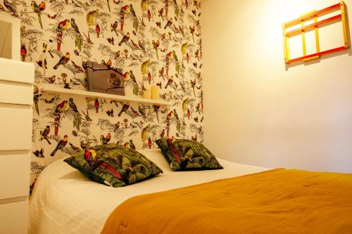 a bedroom with a bed with a wallpaper with birds on it at Laissez-vous enchanter par la Vallée de la Meuse in Hastière-par-delà