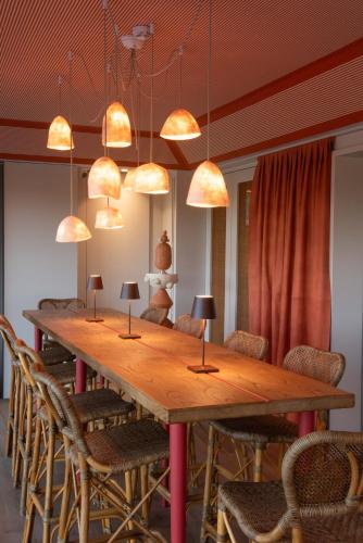 a large wooden table with chairs and lamps at Solar de Vila Meã in Barcelos