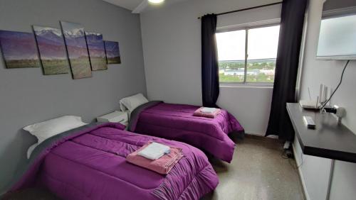 two beds in a room with purple blankets at Cavas de Mendoza - Syrah - 3 habitaciones - Frente al Shopping in Guaymallen