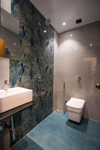 a bathroom with a sink and a toilet at The Platinum in Mumbai