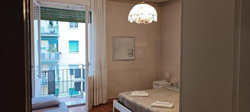 a bedroom with a bed and a window and a chandelier at Affittacamere Pratello 97 in Bologna