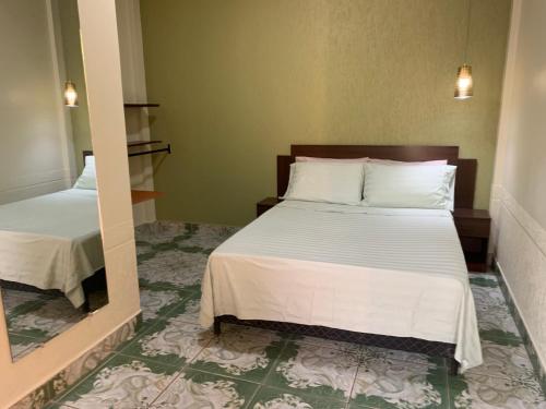 Schlafzimmer mit einem Bett und einem Spiegel in der Unterkunft Alojamiento céntrico in Cobija