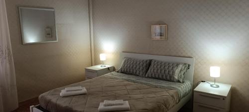 a bedroom with a bed with two night stands and two lamps at Affittacamere Pratello 97 in Bologna