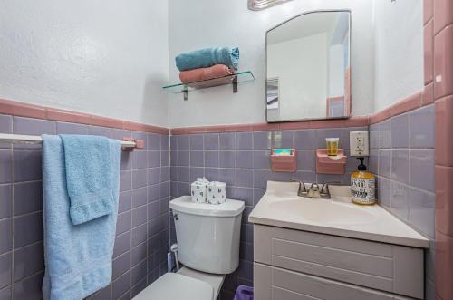 bagno con servizi igienici, lavandino e specchio di Blue Water Beachside Villa 6 a Clearwater Beach