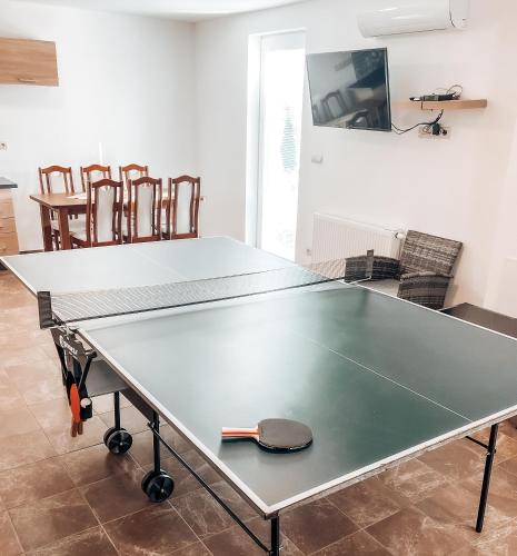 a ping pong table in a room with chairs at Rezidencia Podhájska in Podhájska