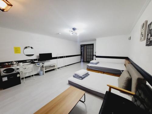 a living room with two beds and a couch at Morning Beach Pension in Jeju