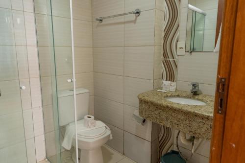 a bathroom with a toilet and a sink at HANNA Balneário Hotel in Balneário Camboriú