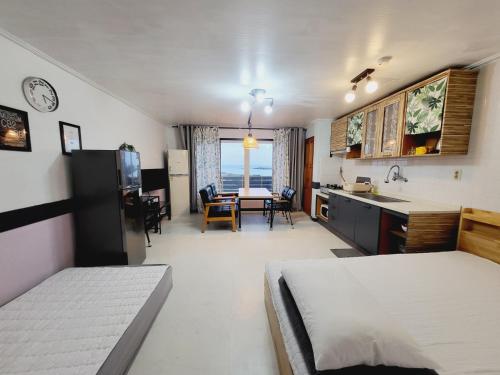 a room with a kitchen and a dining room at Morning Beach Pension in Jeju